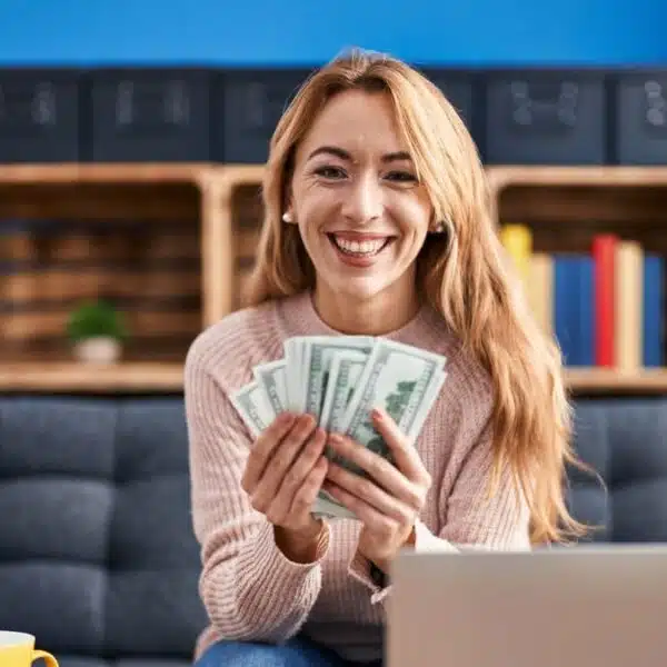 woman holding cash sitting on the couch