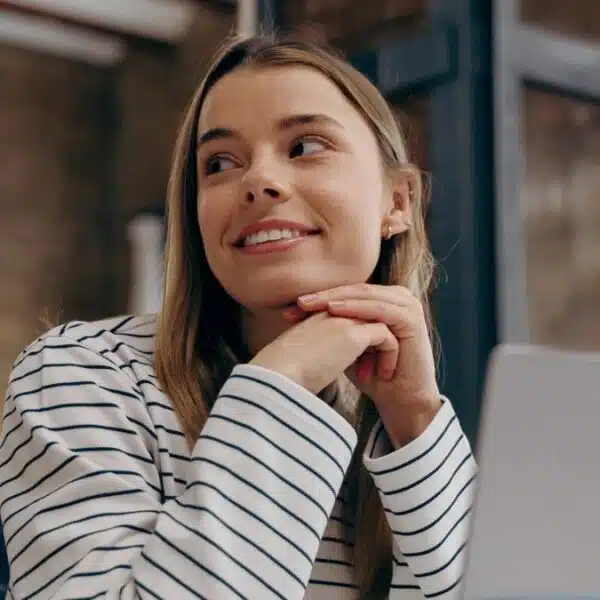 Girl sitting in the office smiling in front of laptop