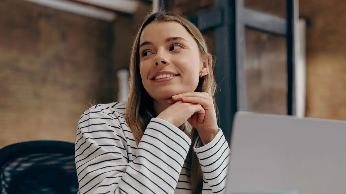 Girl sitting in the office smiling in front of laptop