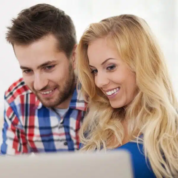 Happy couple sharing thoughts on their laptop