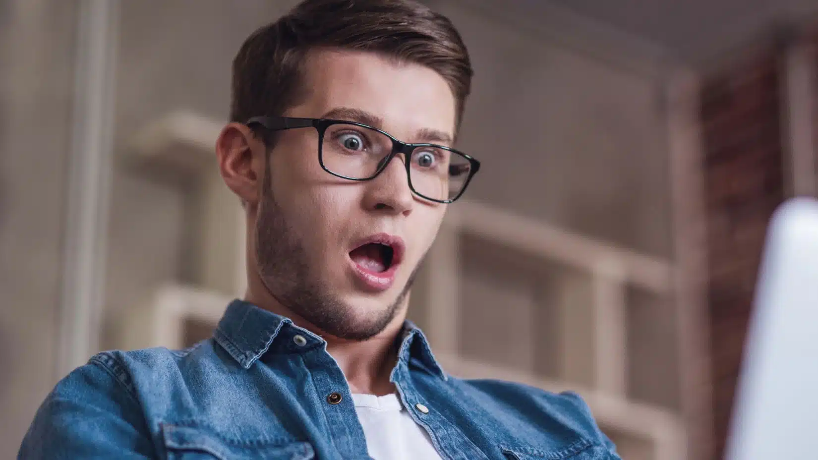 man shocked looking at his bank account