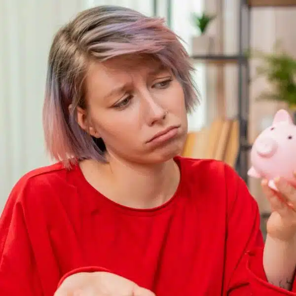 sad woman holding a piggy bank