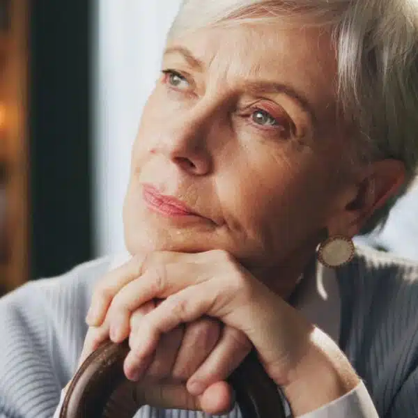 senior woman with cane thinking at home