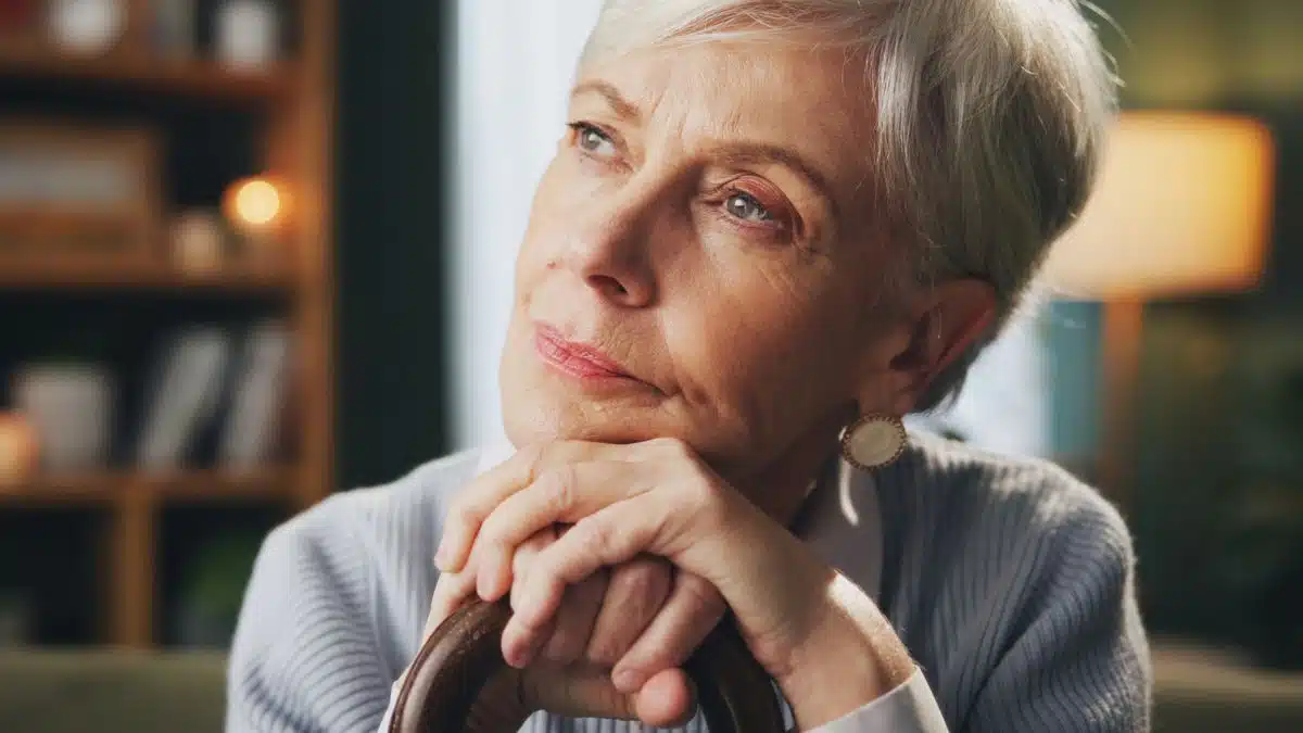 senior woman with cane thinking at home