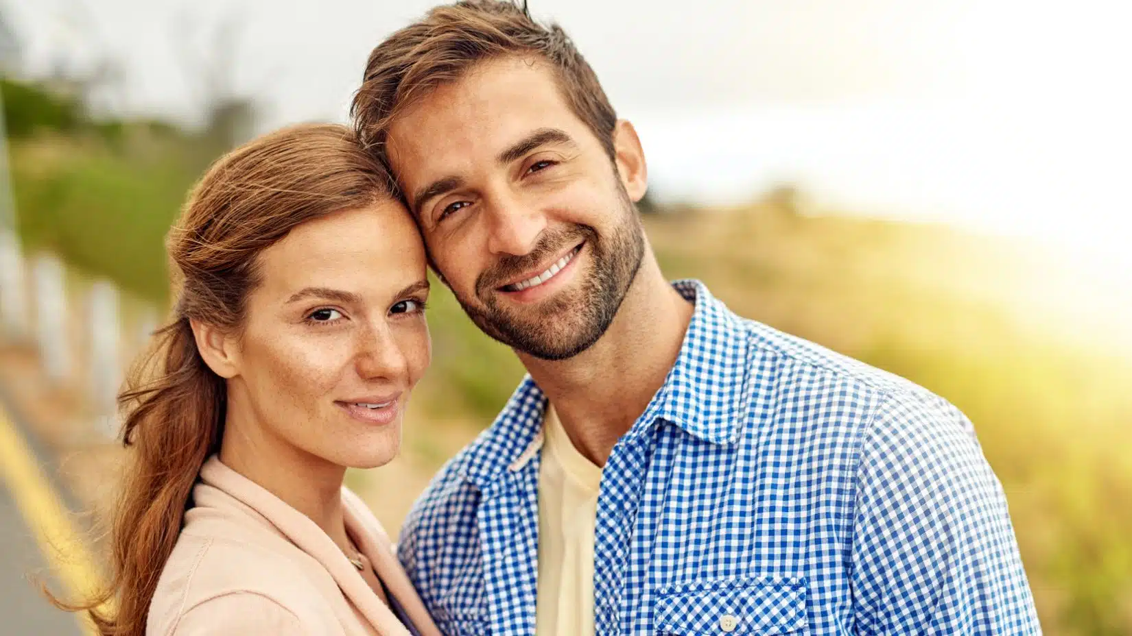 smiling couple outside on the side of the road