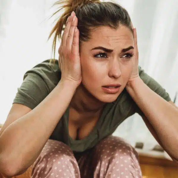 woman covering her ears
