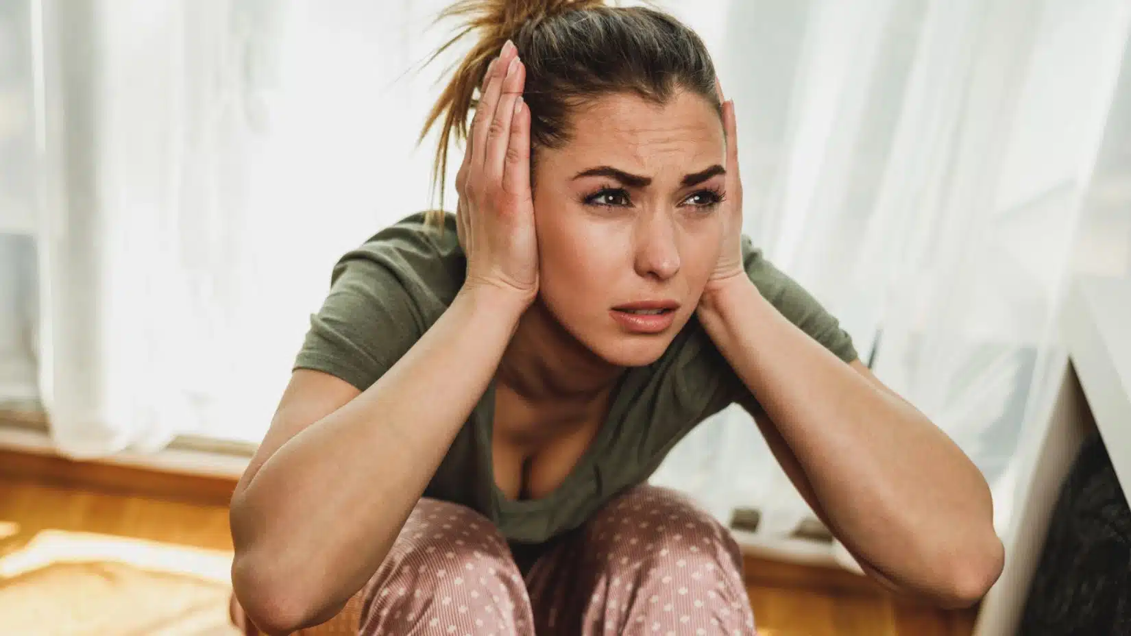 woman covering her ears