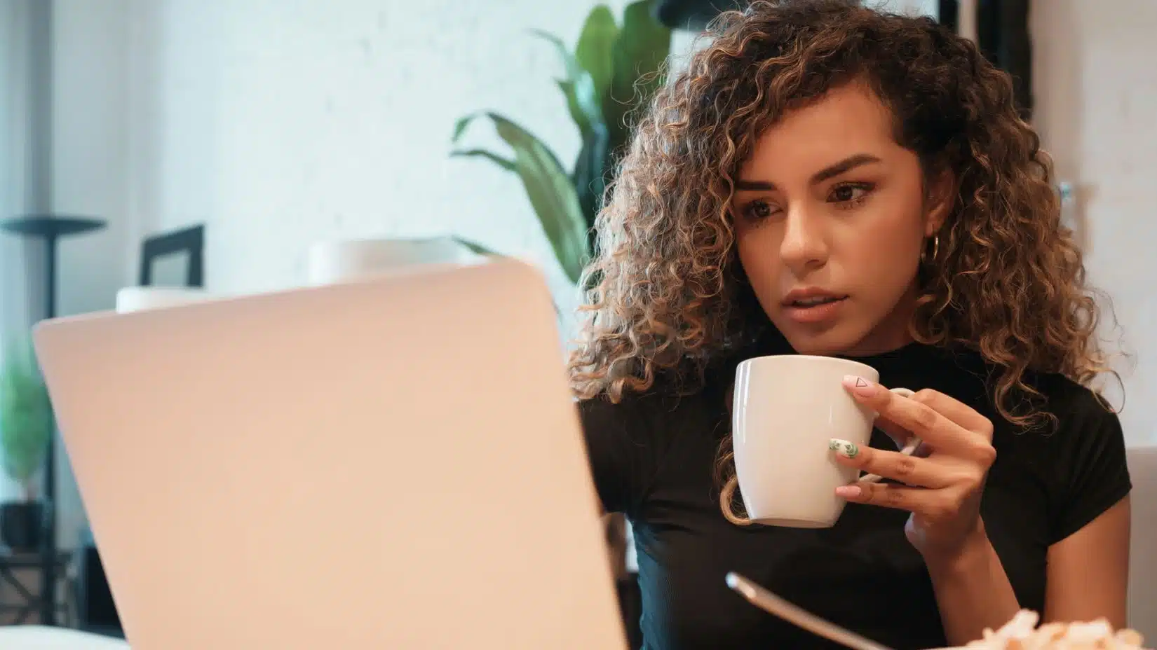 woman drinking coffee and working from home