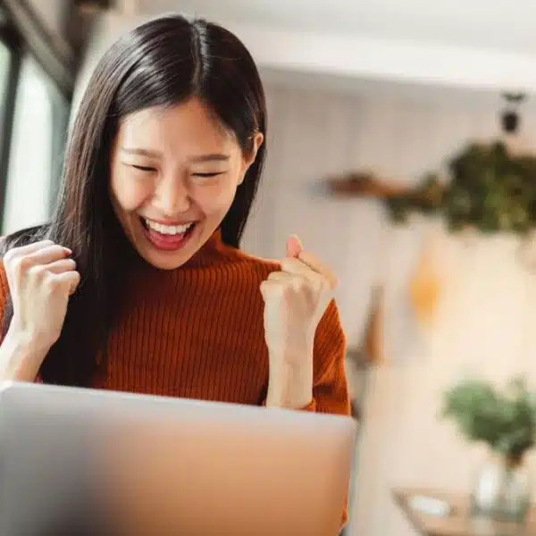 woman happy sitting at a laptop