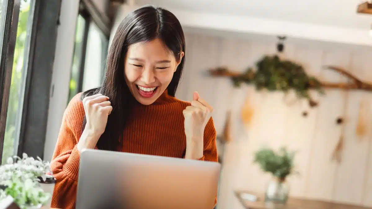 woman happy sitting at a laptop