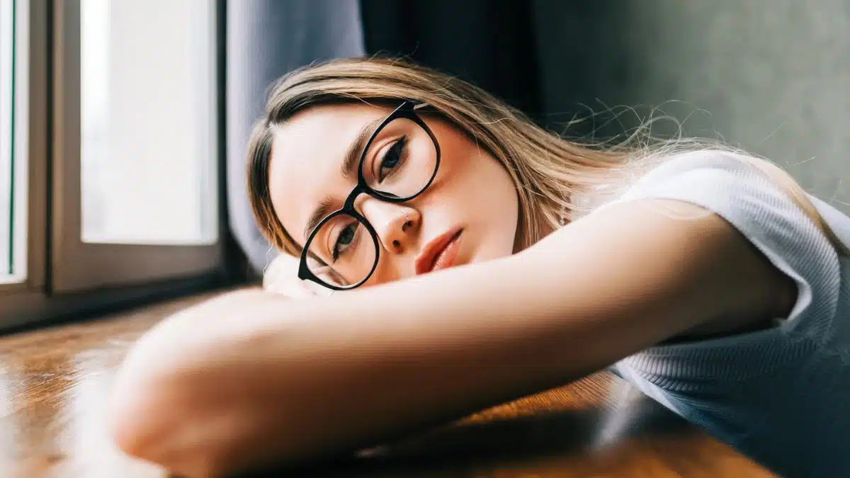 woman resting her head down with glasses