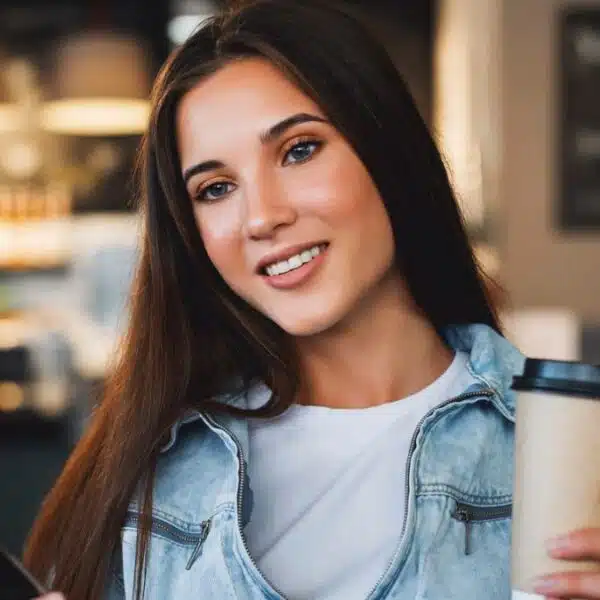 woman sitting in a coffee shop holding her phone