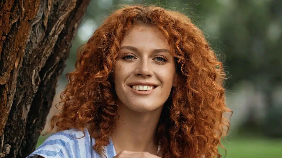 woman sitting next to a tree outside