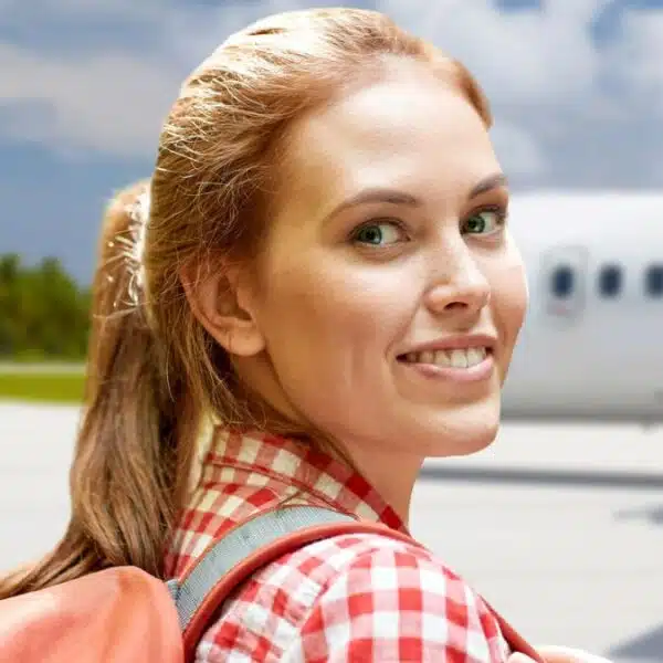 woman smiling in front of airplane