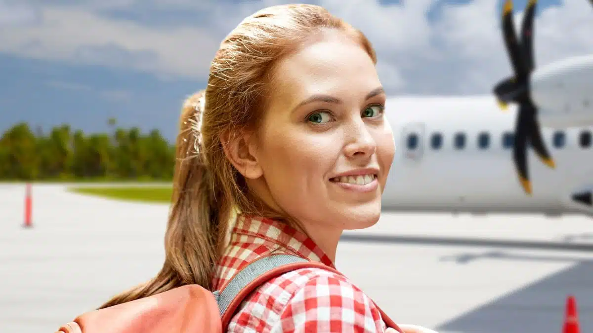 woman smiling in front of airplane