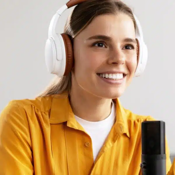 woman smiling talking on a podcast mic