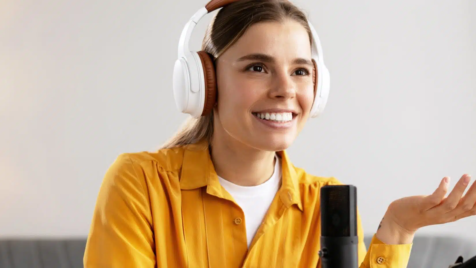 woman smiling talking on a podcast mic