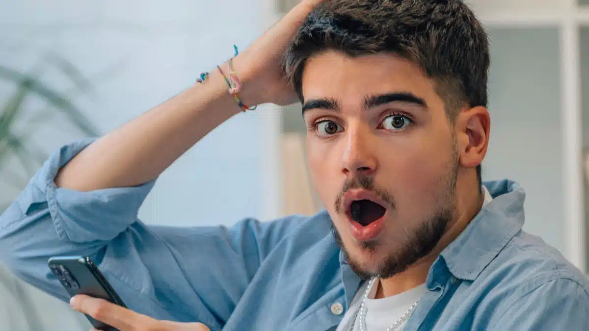 young man shocked reading his phone