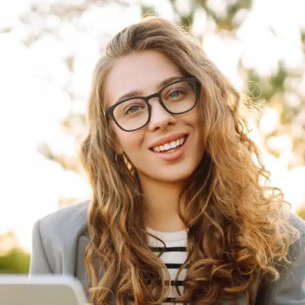 curry hair woman working on laptop outside