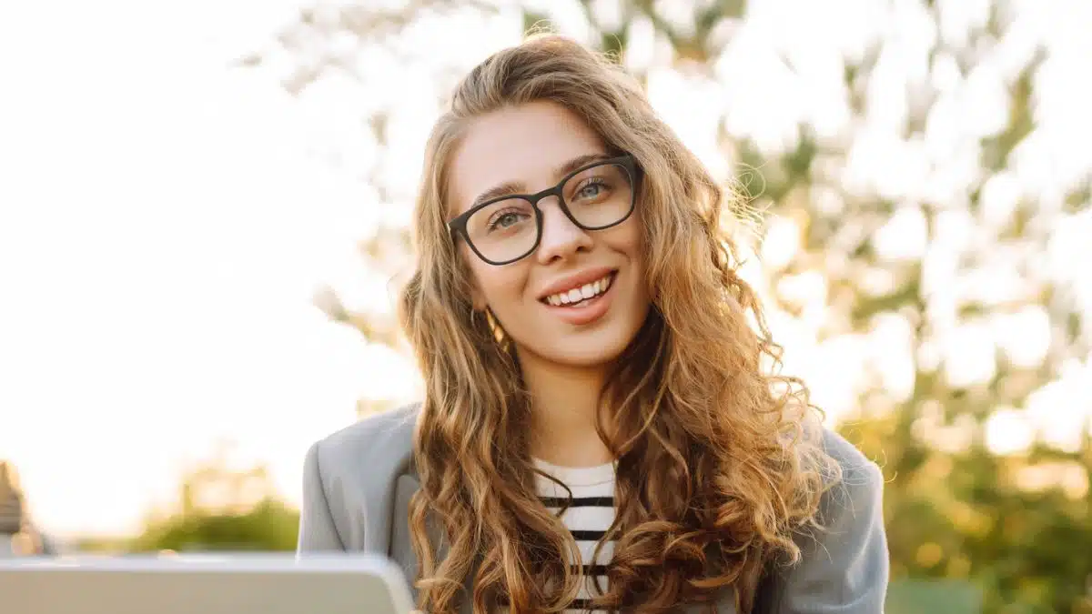 curry hair woman working on laptop outside