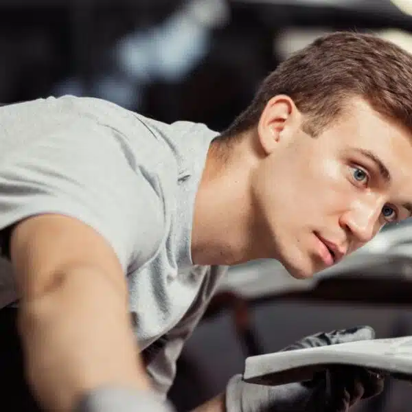 man looking over a sports car