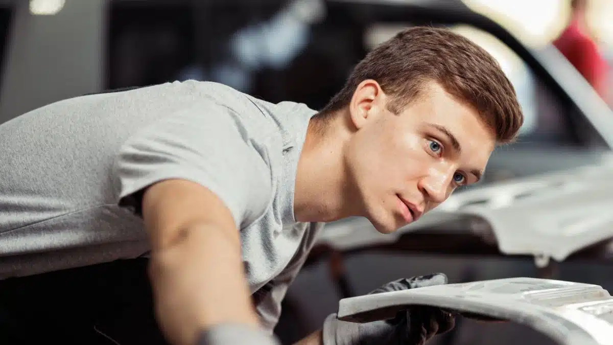 man looking over a sports car