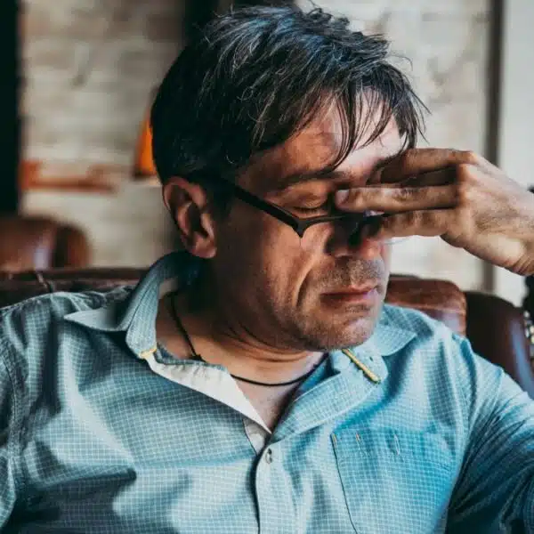 man with a headache sitting in a chair