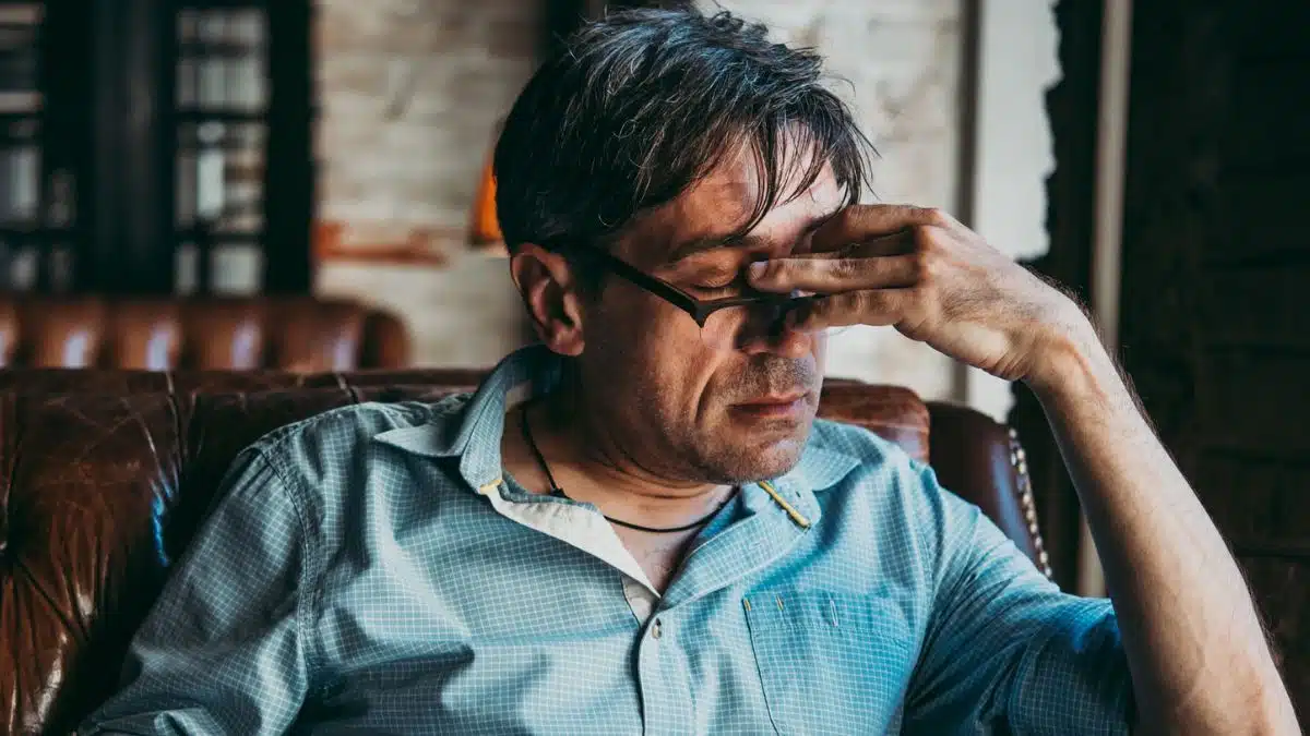 man with a headache sitting in a chair