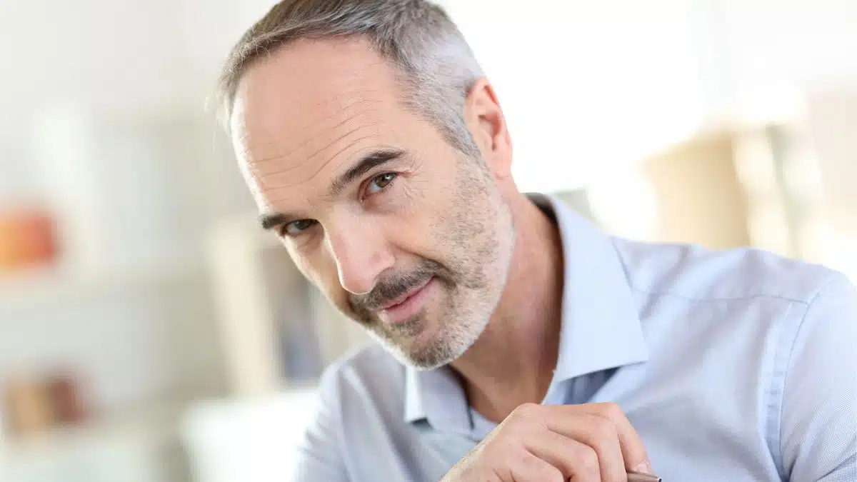 mature man with a pen at home