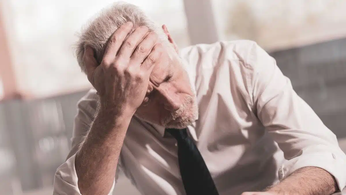 older man working in the office alone stressed