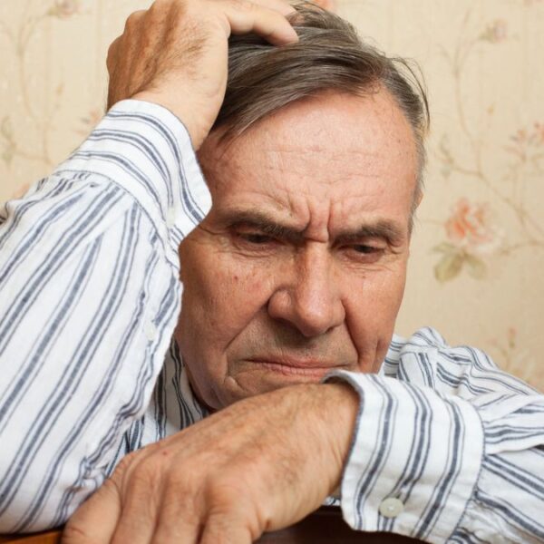 senior man leaning on a chair stressed