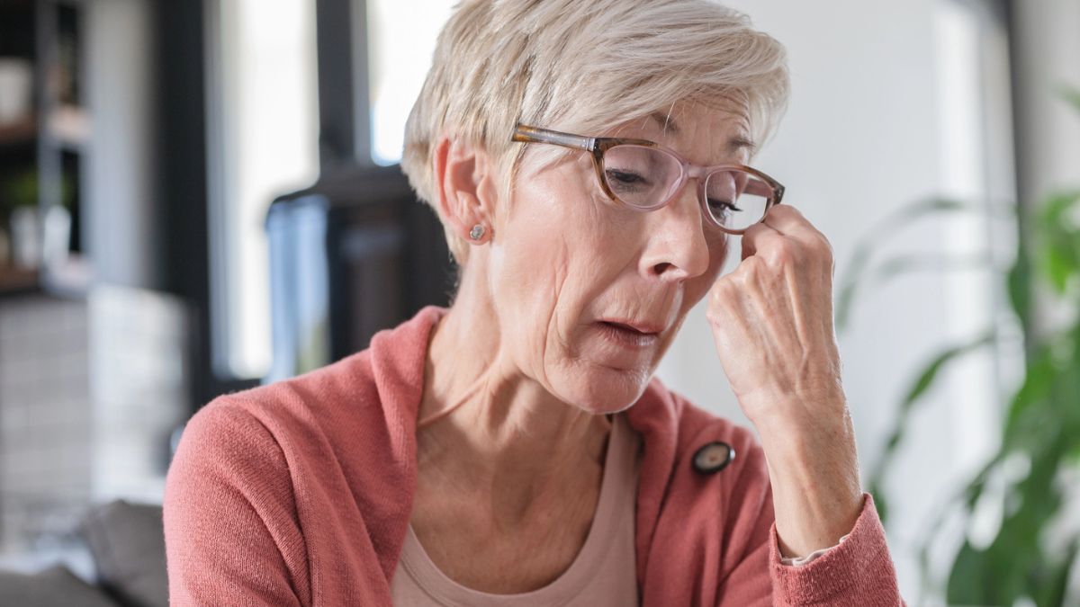 senior woman glasses crying at home
