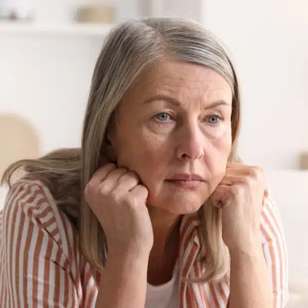 senior woman sitting on the couch wondering