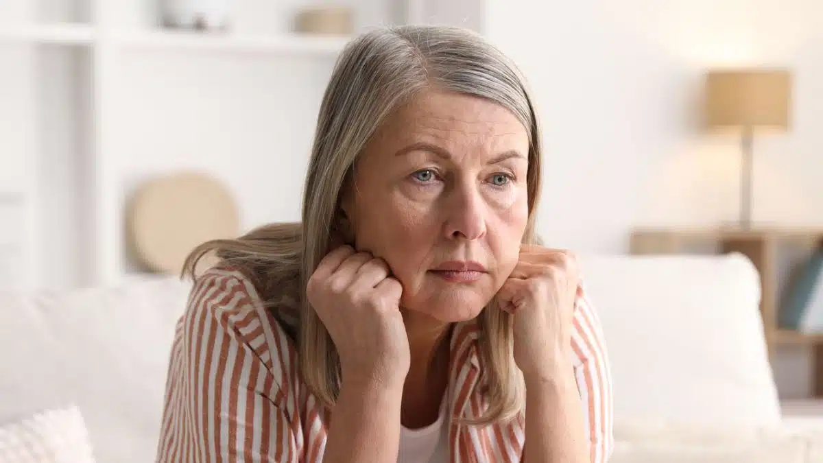 senior woman sitting on the couch wondering