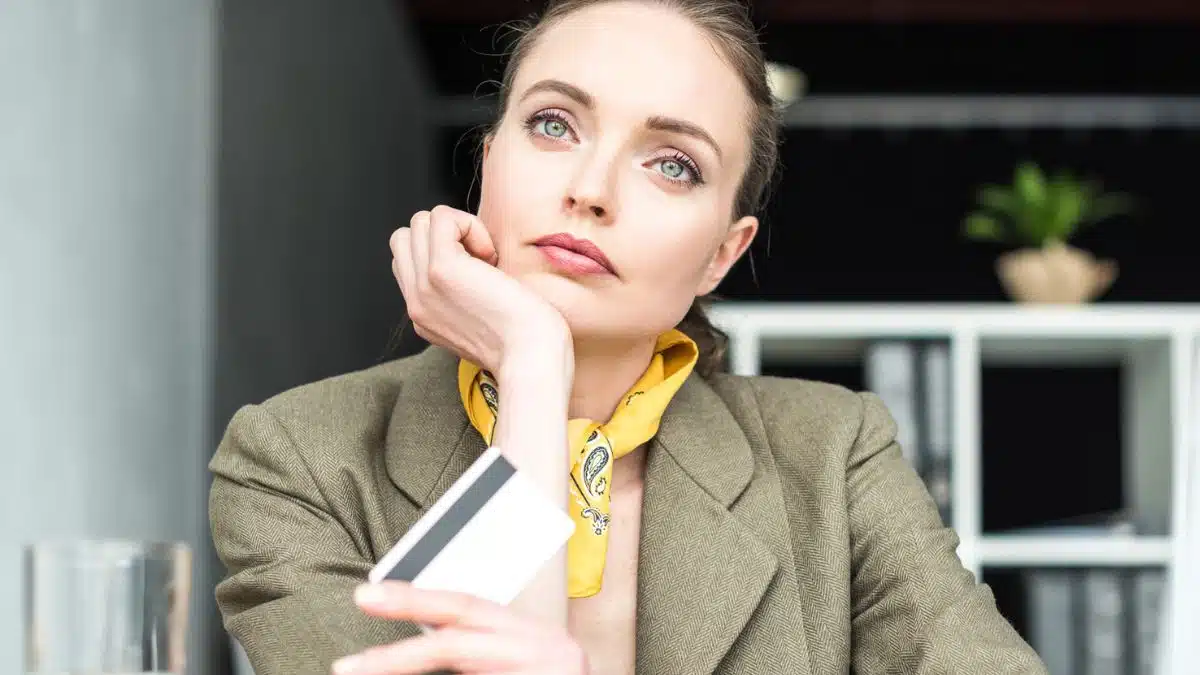 woman bored at desk with credit card