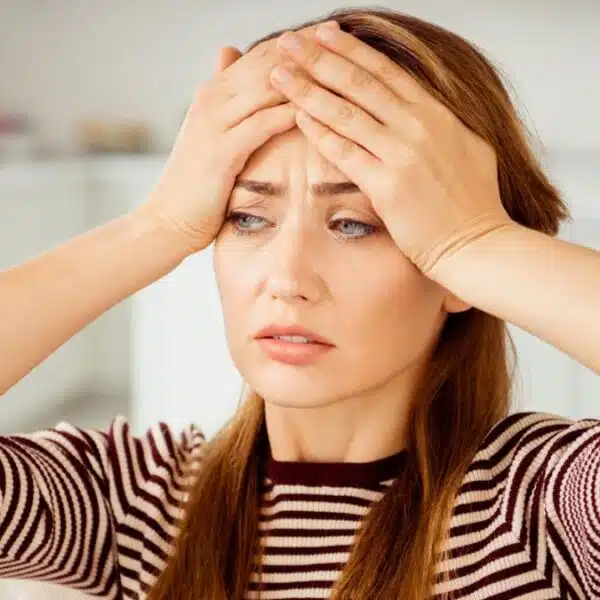 woman holding her head striped shirt
