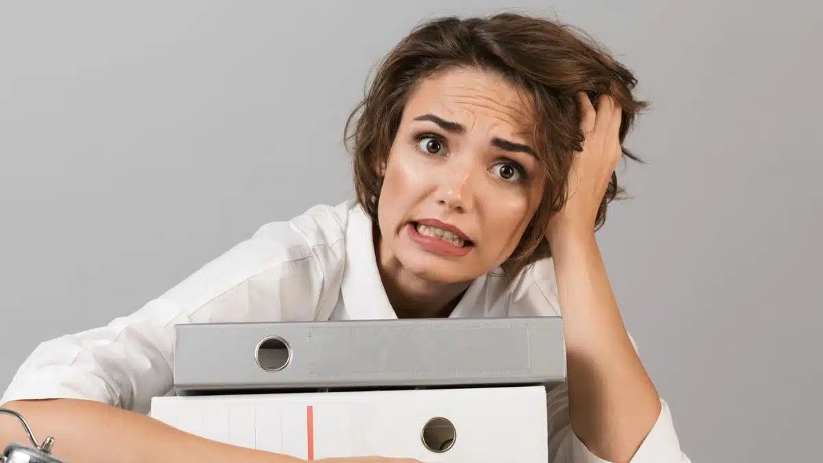 woman overwelmed at work with office folders