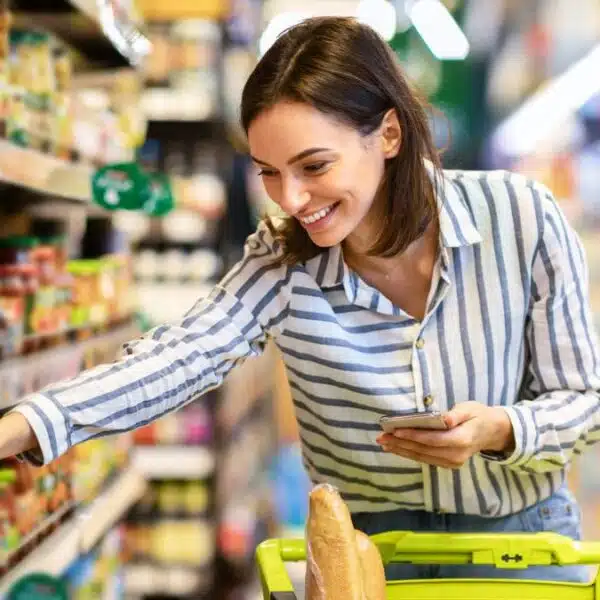 woman picking up items in grocery store