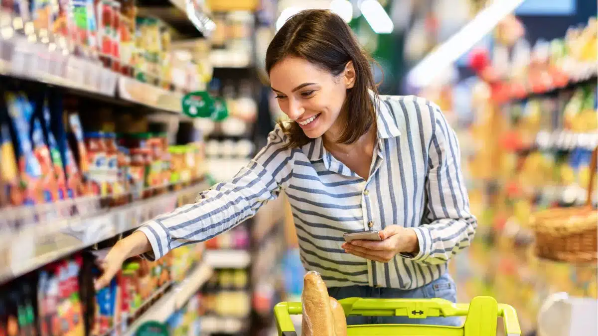 woman picking up items in grocery store