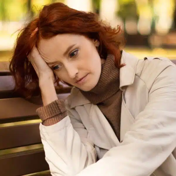 woman sad sitting on a park bench