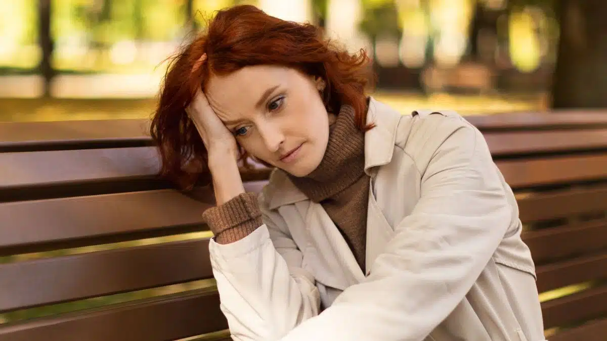 woman sad sitting on a park bench