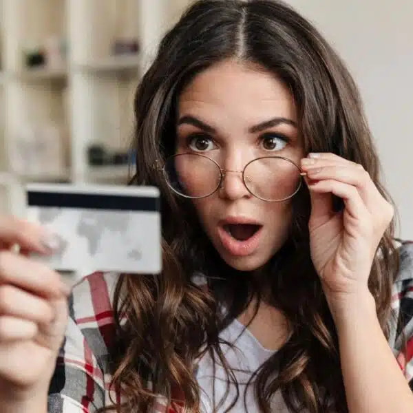 woman with glasses staring at her credit card