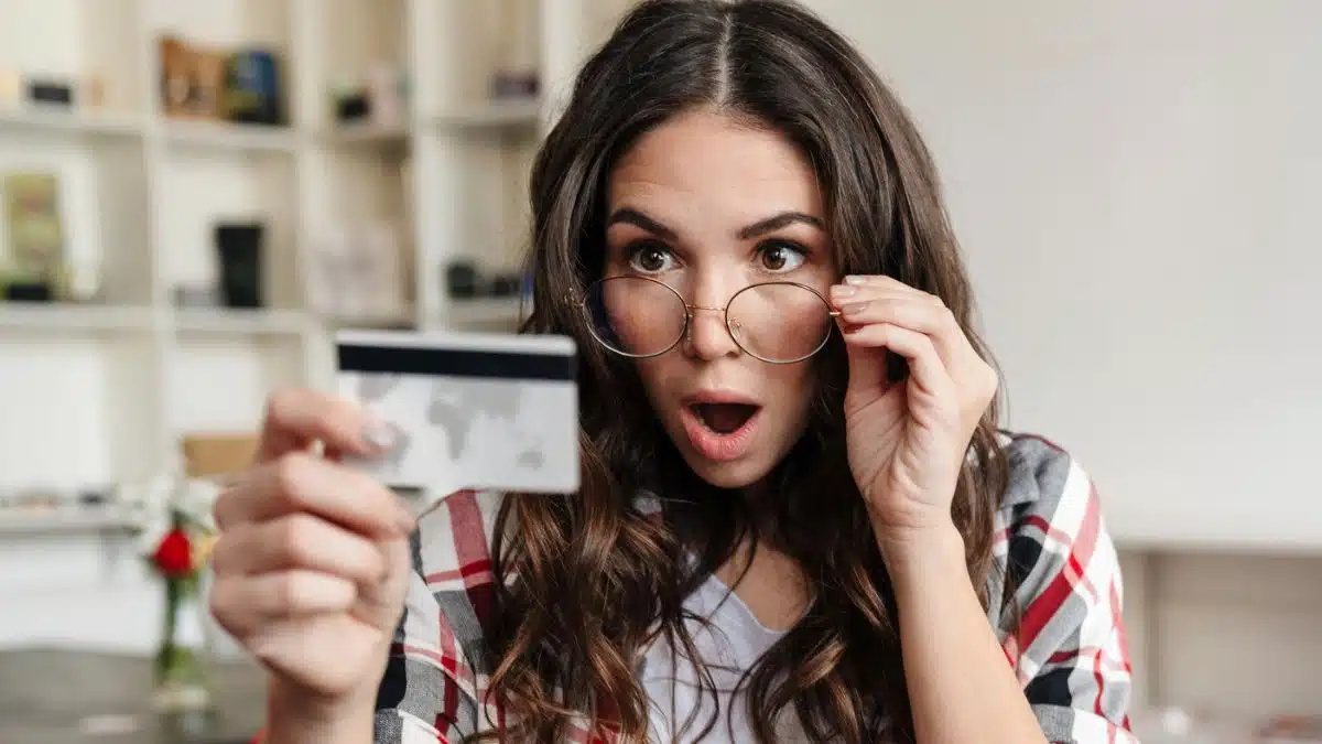 woman with glasses staring at her credit card