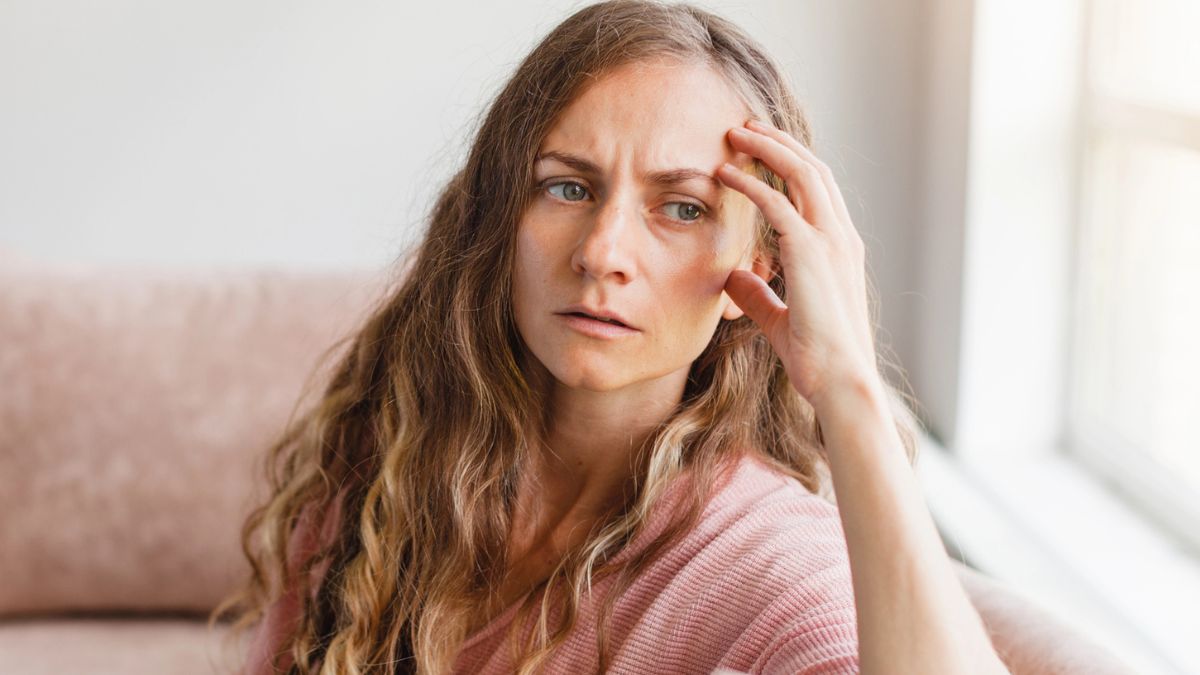 young woman worried looking out the window