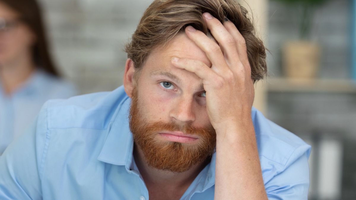 man beard leaning on desk