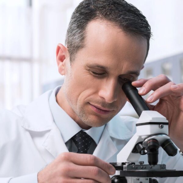 man looking at a microscope