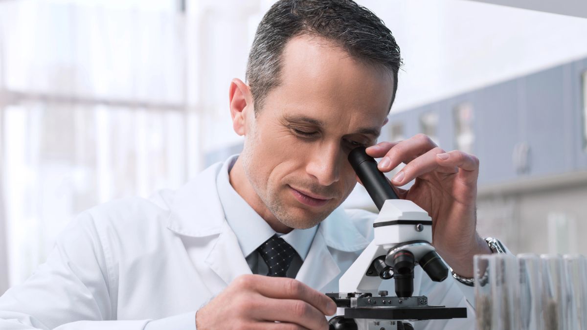 man looking at a microscope
