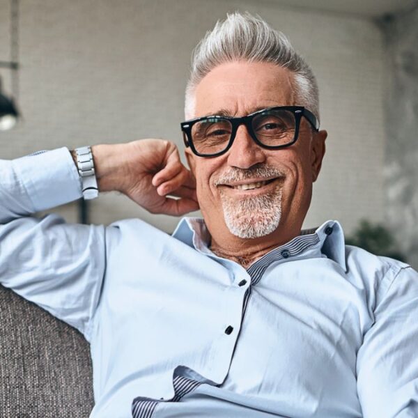 mature man on couch with his laptop