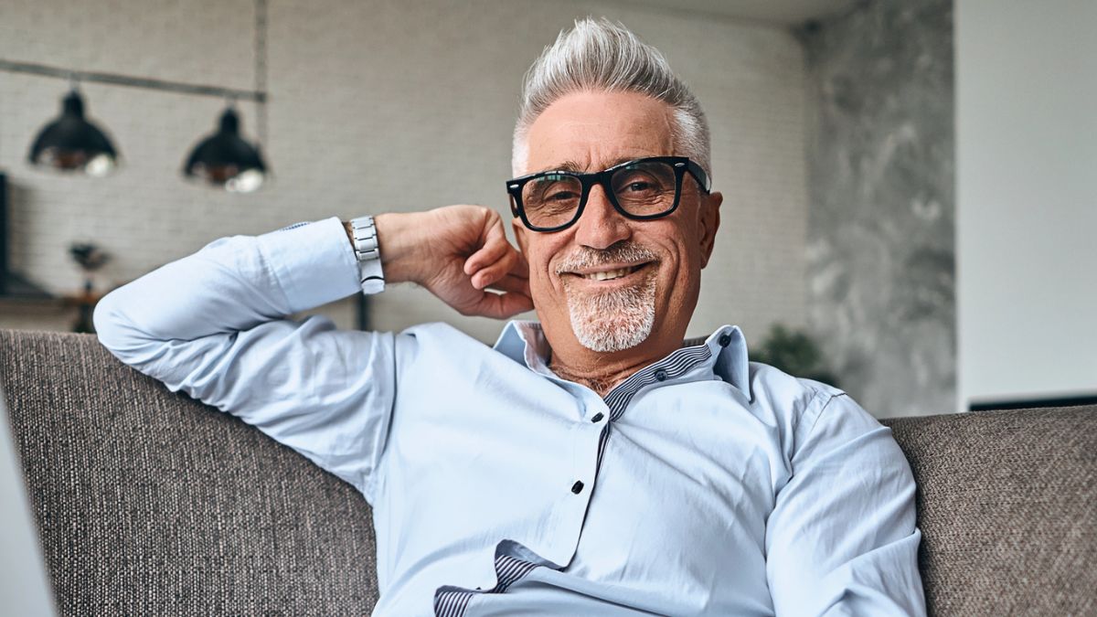 mature man on couch with his laptop