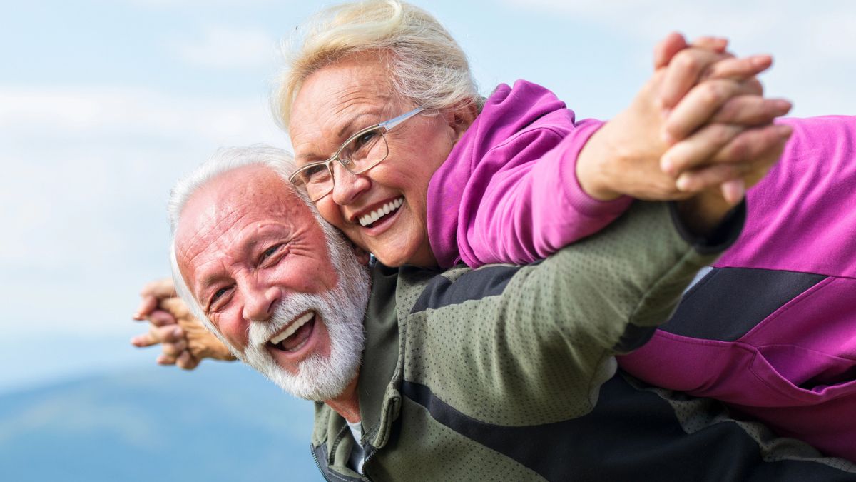 senior couple laughing on a moutain